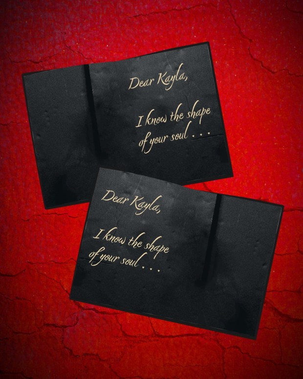 Two black cards with gold lettering that reads 'Dear Kayla, I know the shape of your soul...' against a red textured background.